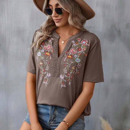 Model wearing a Fashion Flowers Embroidery Lace-collared Blouse with floral embroidery, shorts, and a brown hat.