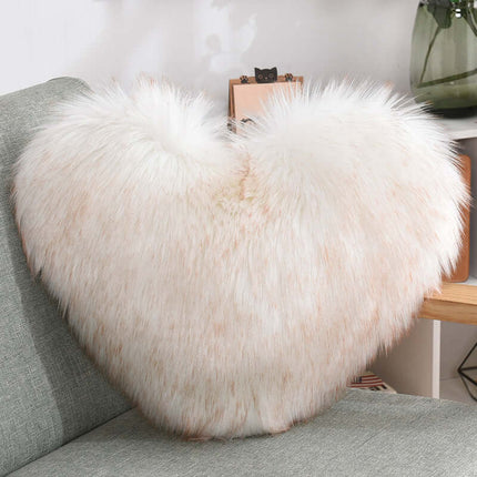Heart Shaped Plush Throw Pillow sitting on a white bed sheet