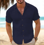 Men Short-Sleeved Button-Down Summer Shirt in navy blue, showcased on a model at the beach.