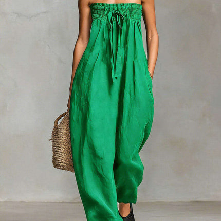 Women Strapless Ruched Jumpsuit Summer Fashion in vibrant green worn with a woven bag and sandals.