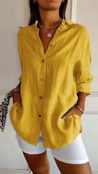 Womens Lapel Long Sleeve Single Breasted Pleated Shirt in vibrant yellow color with buttons and pockets styled with white shorts.