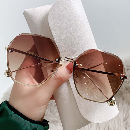 Elegant Fashion Sunglasses for a Slimming Face Look held in a hand with a stylish case.