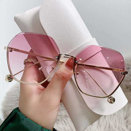 Elegant Fashion Sunglasses for a Slimming Face Look held with a stylish case, showcasing pink lenses and chic design.