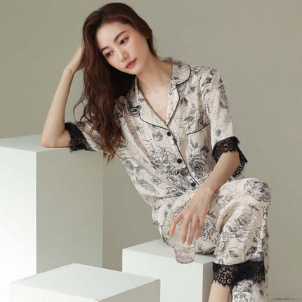 Fashion New Silk Pajamas For Women Luxury Sleepwear Set model sitting elegantly on white blocks holding a glass.