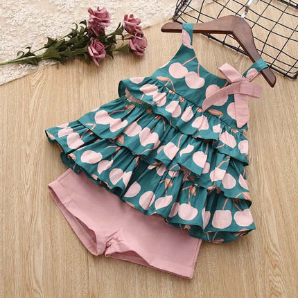 Kids Girls T Shirt And Shorts Two Piece Summer Set featuring a ruffled green top with cherries and pink shorts.