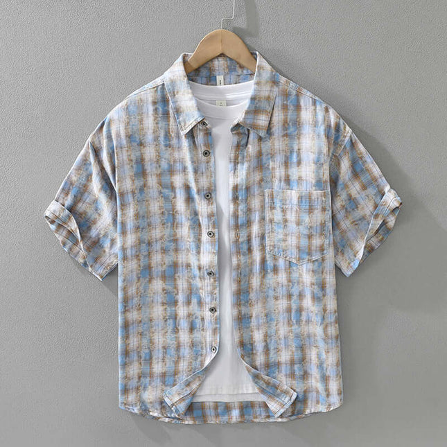 Mens Fashionable Plaid Short Sleeve Shirt in blue and brown tones hung on a hanger, showcasing its stylish design and pure cotton material.