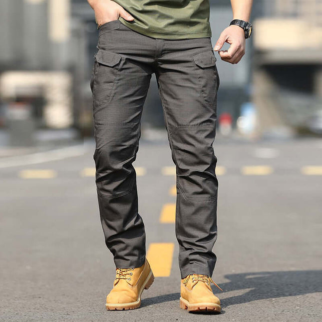 Mens Special Service Outdoor Tactical Training Pants worn by a model standing outdoors in tactical boots.