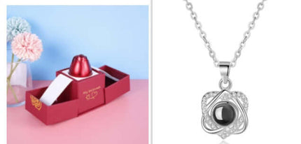 Metal rose jewelry gift box with crystal necklace displayed alongside a delicate silver chain pendant.