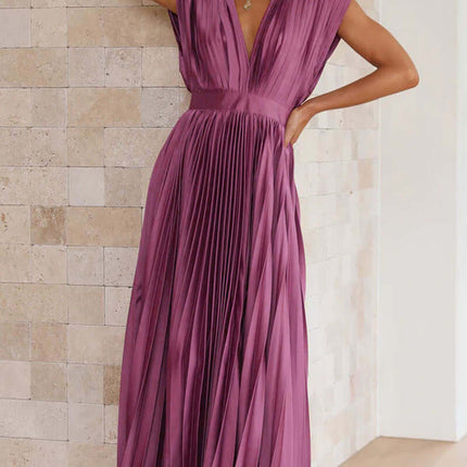 Model wearing Summer V Neck Pleated Sleeveless Maxi Dress in pink, standing against a textured wall.