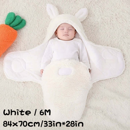 Baby in Super Soft Baby Sleeping Bag Fluffy Fleece Swaddle with bunny ears, resting on a soft blanket.