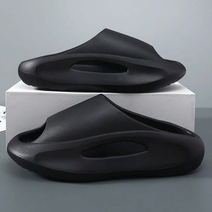 Black unisex hollow peep toe summer EVA slides on a display box.