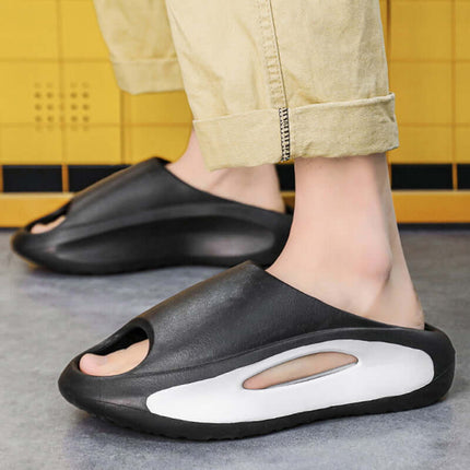Unisex Hollow Peep Toe Summer EVA Slides in black worn on feet with casual pants.