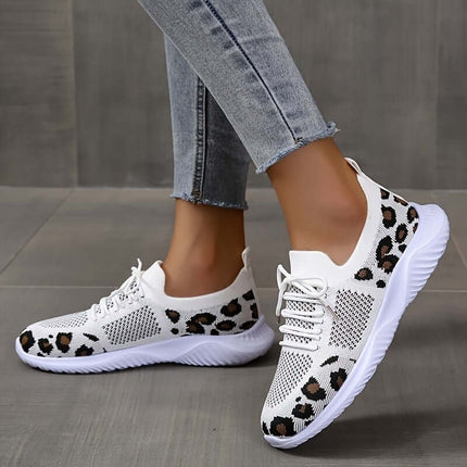 White Shoes Women Leopard Print Lace up Sneakers worn with denim jeans on a tiled floor.