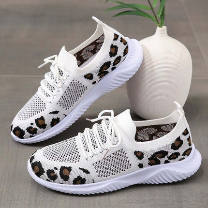White Shoes Women Leopard Print Lace up Sneakers displayed beside a vase, showcasing stylish and trendy footwear.