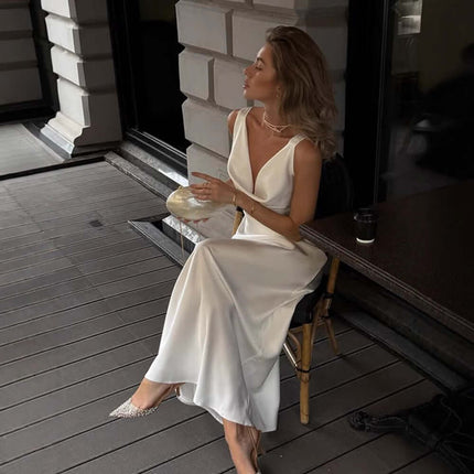 Women Fashion French Style Sleeveless V-Neck Dress worn by a woman sitting elegantly outdoors.