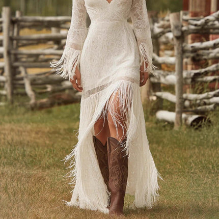 Woman wearing a Womens Boho Lace Maxi Dress With Tassels and brown cowboy boots, standing in a grassy area with wooden fence.