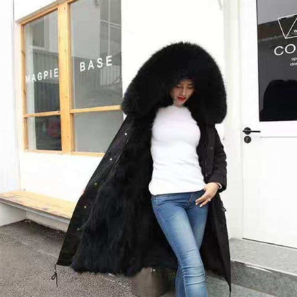 Womens Cashmere Coat With Detachable Liner displayed outdoors, featuring a luxurious fur-lined hood and stylish black design.