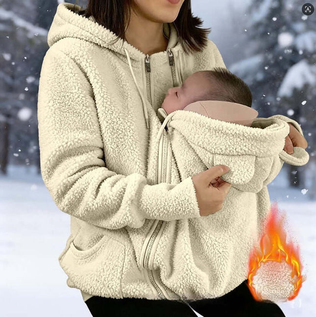 Womens Corduroy Hooded Jacket With Baby Pocket displayed on a woman holding a baby in a snowy background.