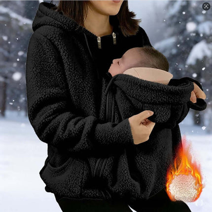 Womens Corduroy Hooded Jacket With Baby Pocket worn by a woman holding a baby in a snowy environment.