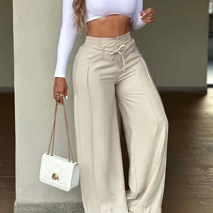 Woman wearing Women's High Waist Wide Leg Drawstring Multi Pocket Pants with a white crop top and handbag.