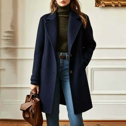 Women's Retro Casual Mid-Length Lapel Coat worn with a green sweater and blue jeans, featuring a chic handbag.